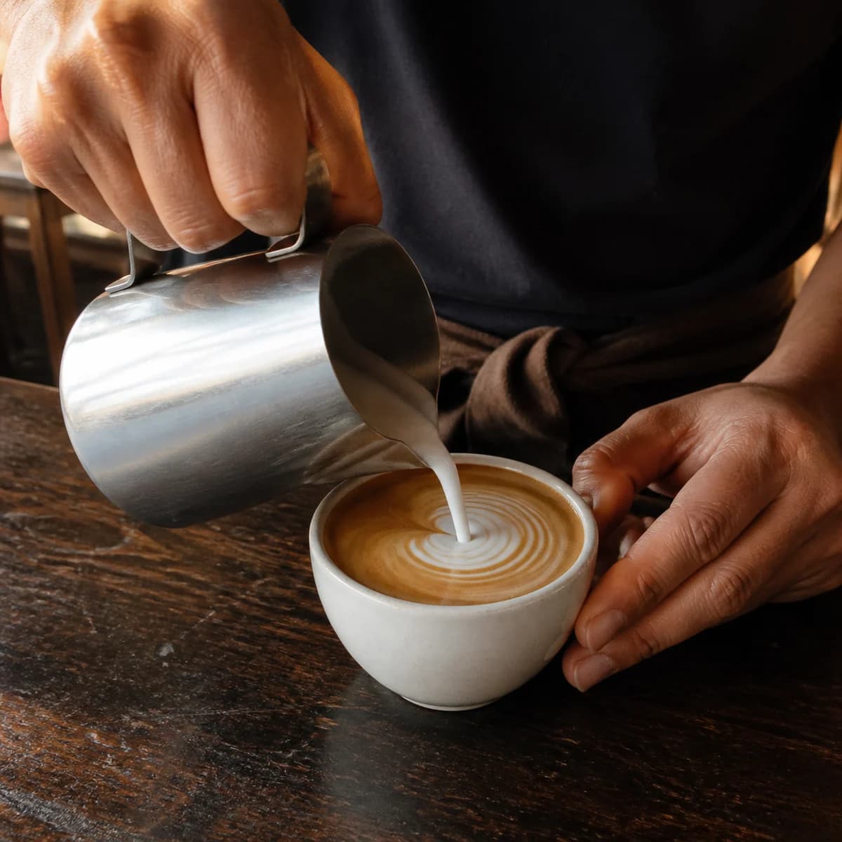 AI-generated concept photograph of barista hands pouring milk into coffee